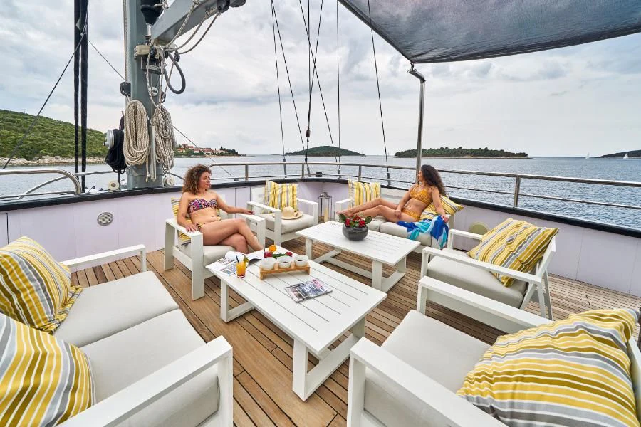 a couple of women sitting on a boat on the water aboard RARA AVIS Yacht for Charter