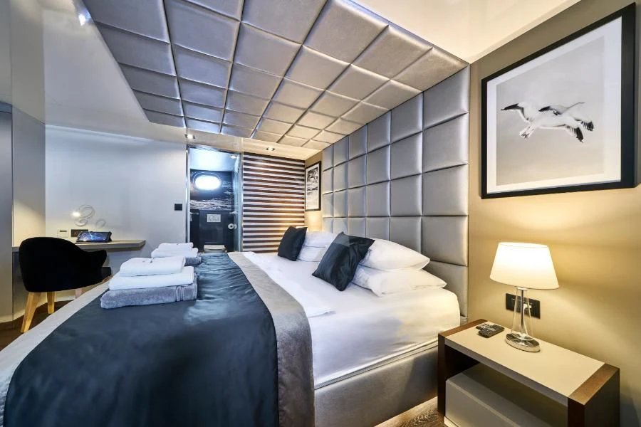a bedroom with a bed and a desk aboard RARA AVIS Yacht for Charter