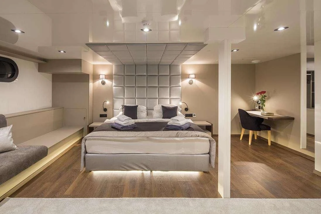 a room with a bed and a chair aboard RARA AVIS Yacht for Charter