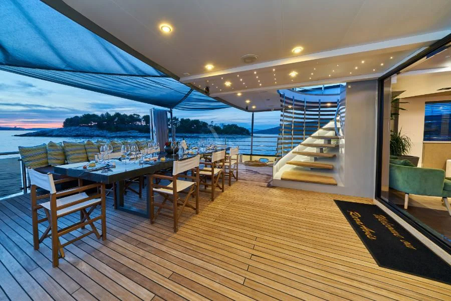 a deck with a table and chairs aboard RARA AVIS Yacht for Charter