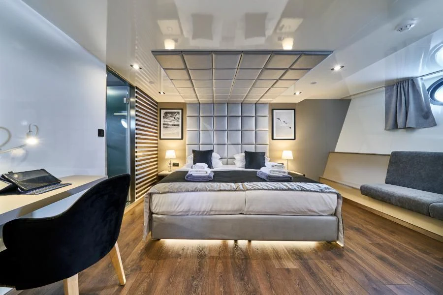 a bedroom with a bed and a desk aboard RARA AVIS Yacht for Charter