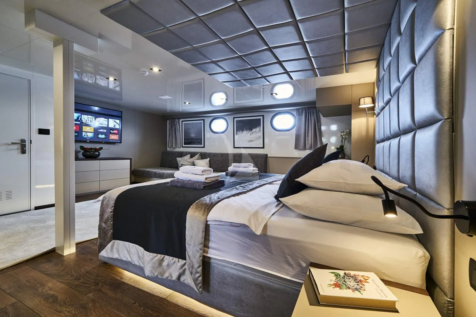 a bedroom with a bed and a tv aboard RARA AVIS Yacht for Charter