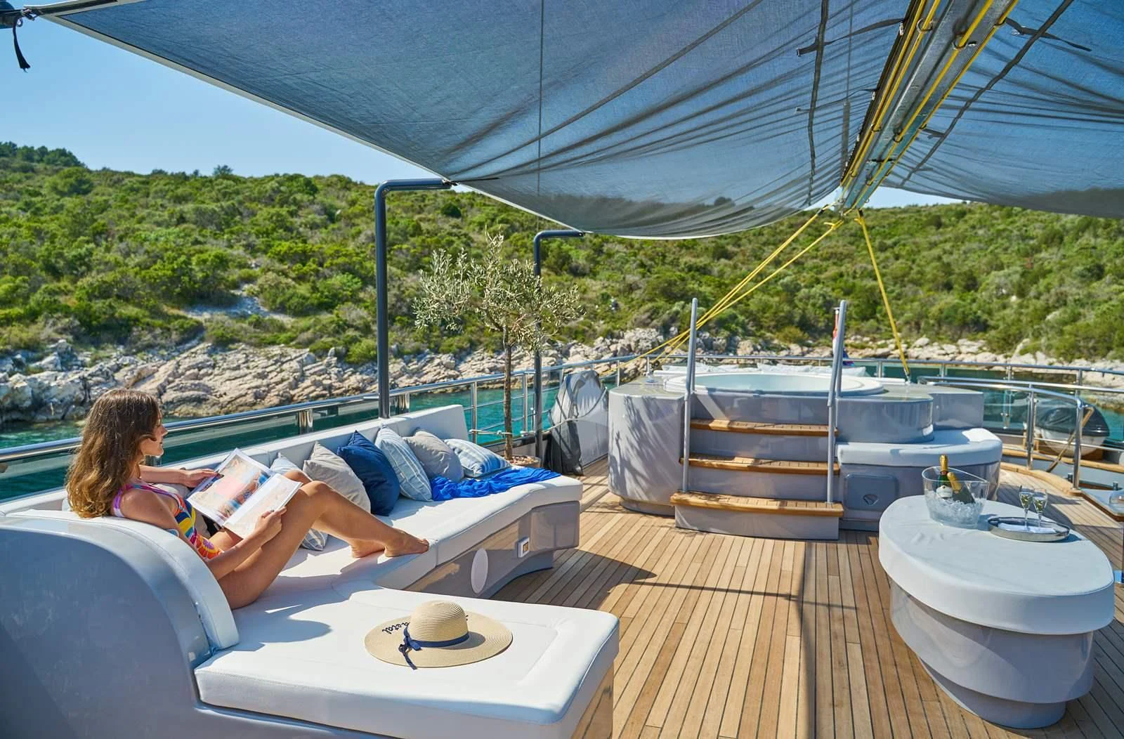 a woman reading a book on a deck aboard RARA AVIS Yacht for Charter