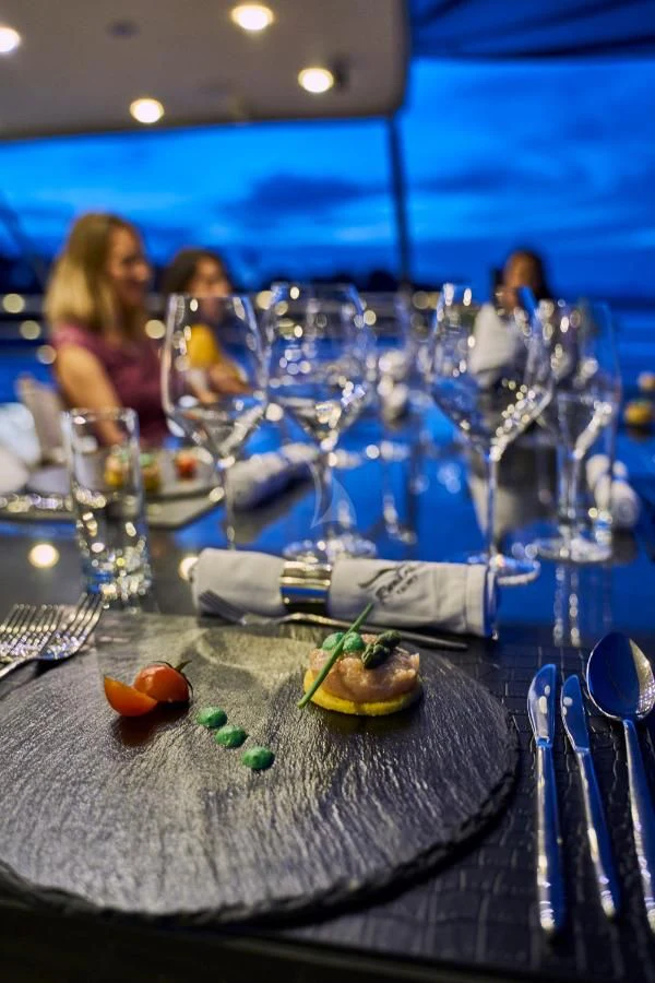 a table with a group of people sitting at it aboard RARA AVIS Yacht for Charter