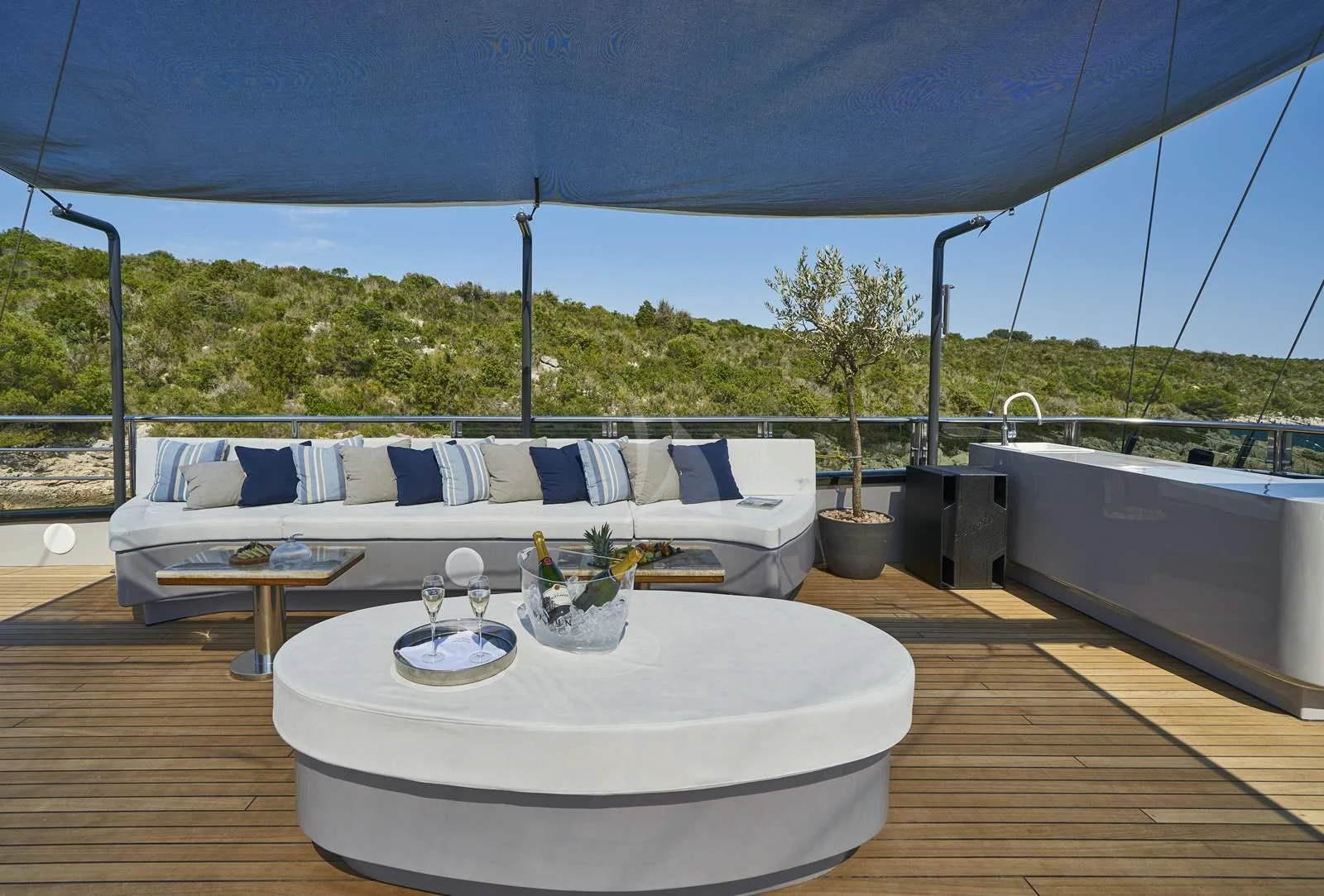 a large white bed with a table and chairs on a deck aboard RARA AVIS Yacht for Charter