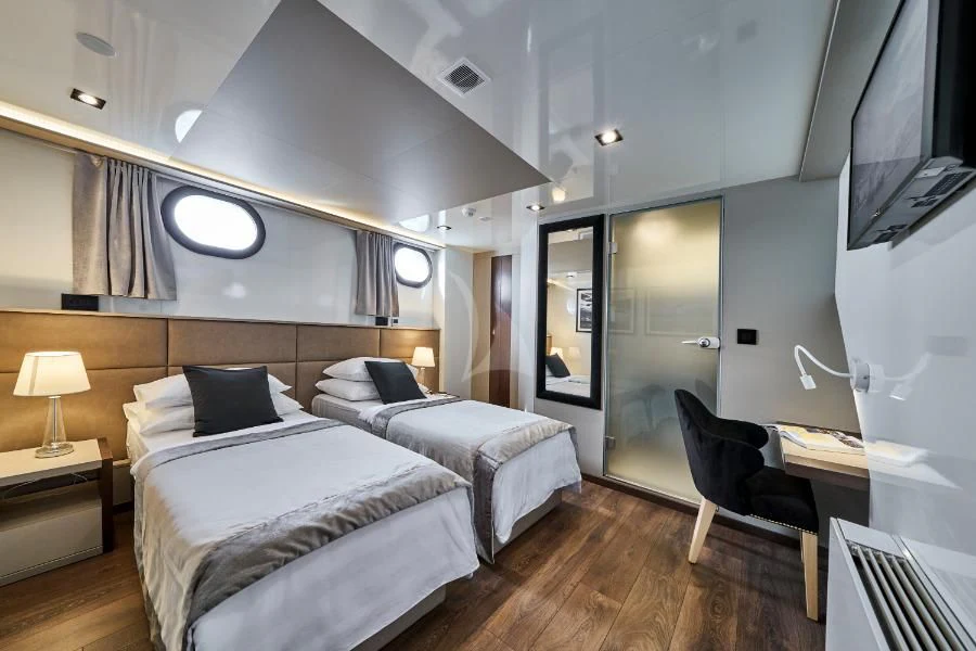 a bedroom with a bed and a tv aboard RARA AVIS Yacht for Charter