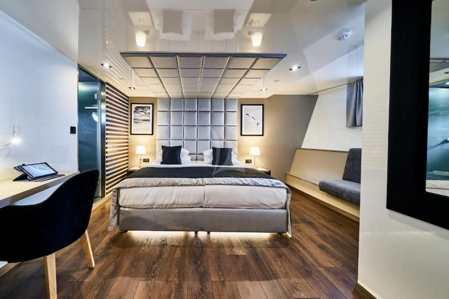 a bedroom with a bed and a desk aboard RARA AVIS Yacht for Charter