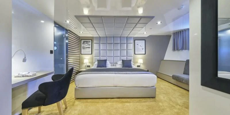 a bedroom with a bed and a desk aboard RARA AVIS Yacht for Charter