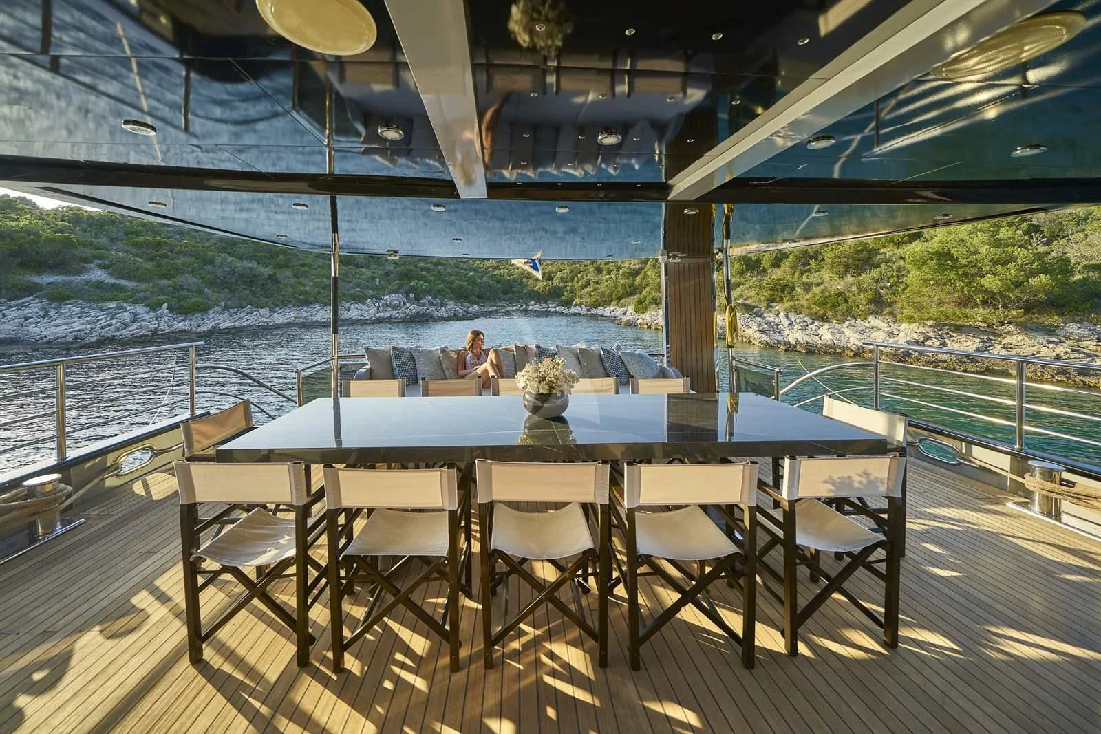 a table and chairs on a deck overlooking a body of water aboard RARA AVIS Yacht for Charter