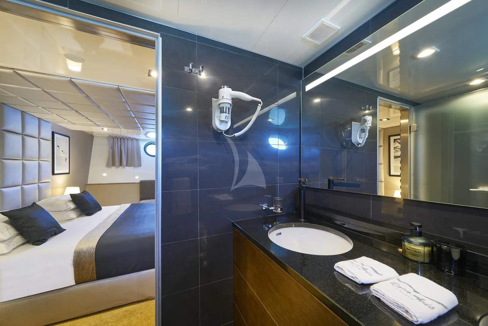 a bathroom with a sink and a bed aboard RARA AVIS Yacht for Charter
