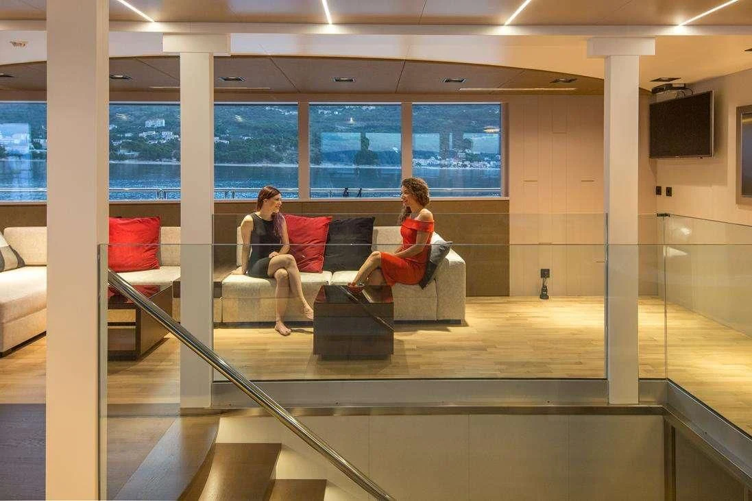 a couple of women sitting on a couch in a building aboard RARA AVIS Yacht for Charter