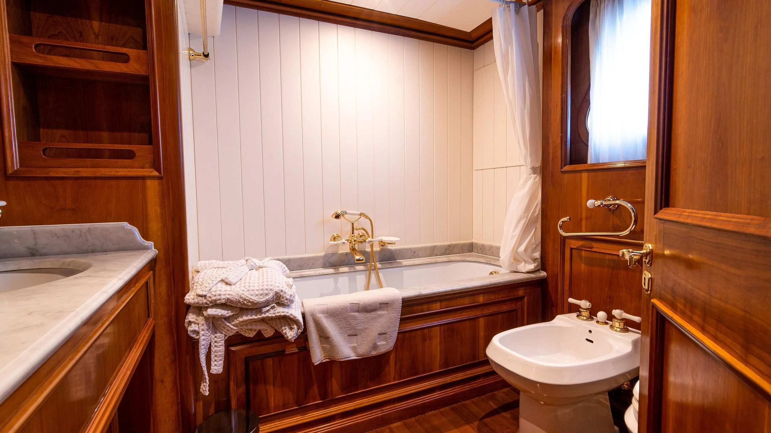 a bathroom with a bathtub sink and a sink aboard A&A Yacht for Charter