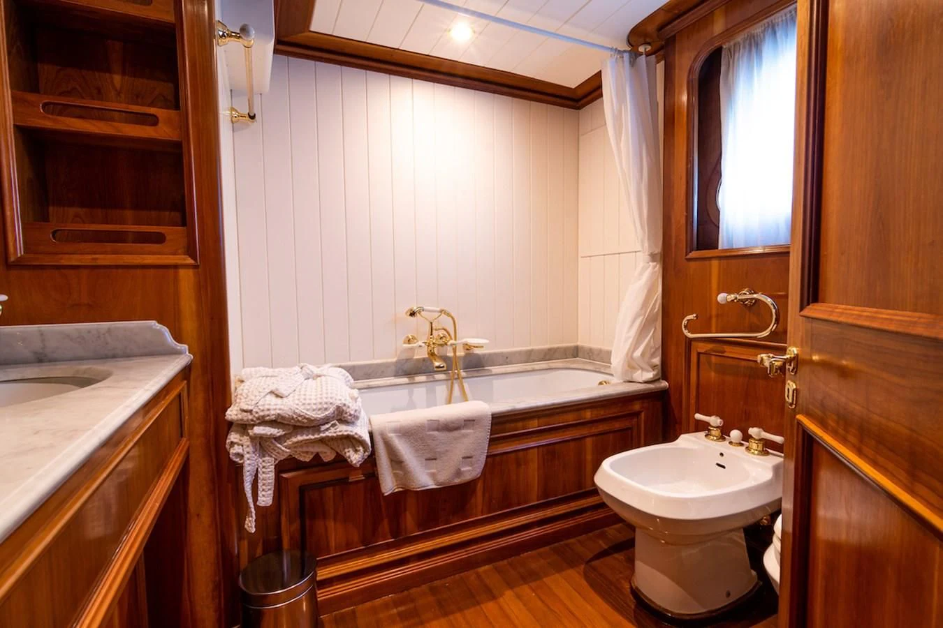 a bathroom with a tub sink and a sink aboard A&A Yacht for Charter