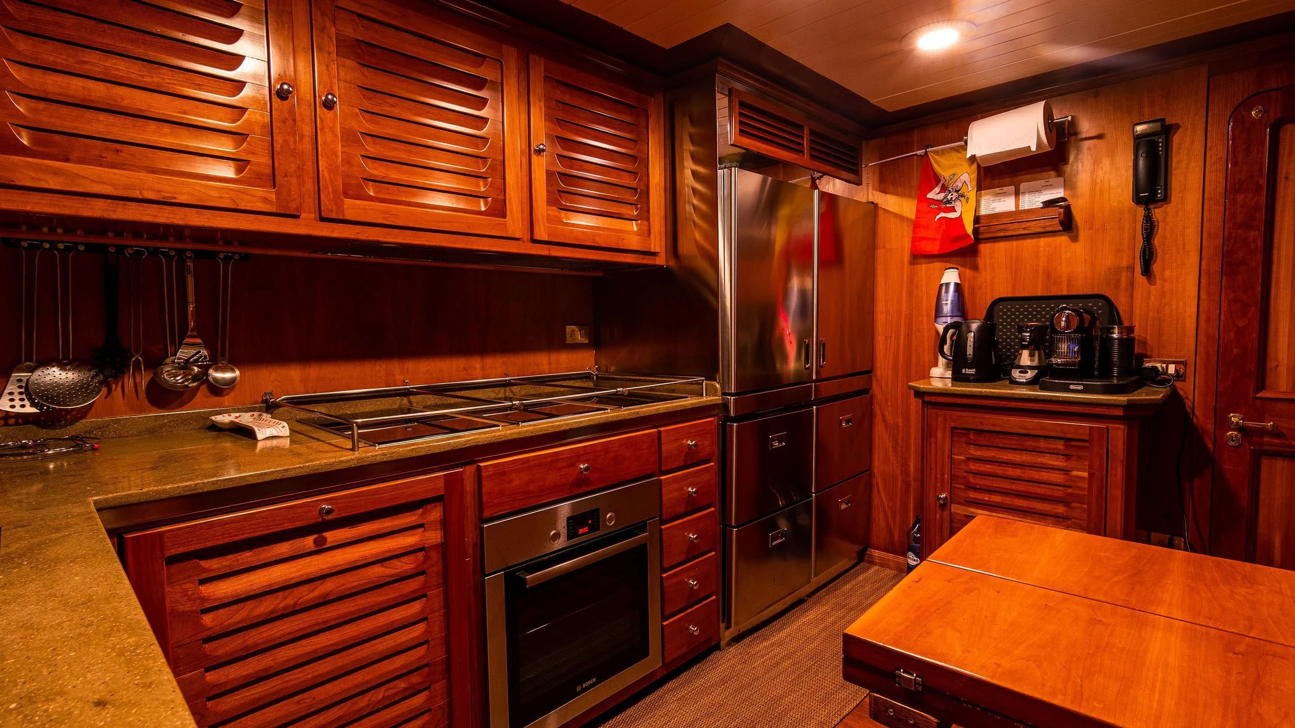 a kitchen with wooden cabinets aboard A&A Yacht for Charter