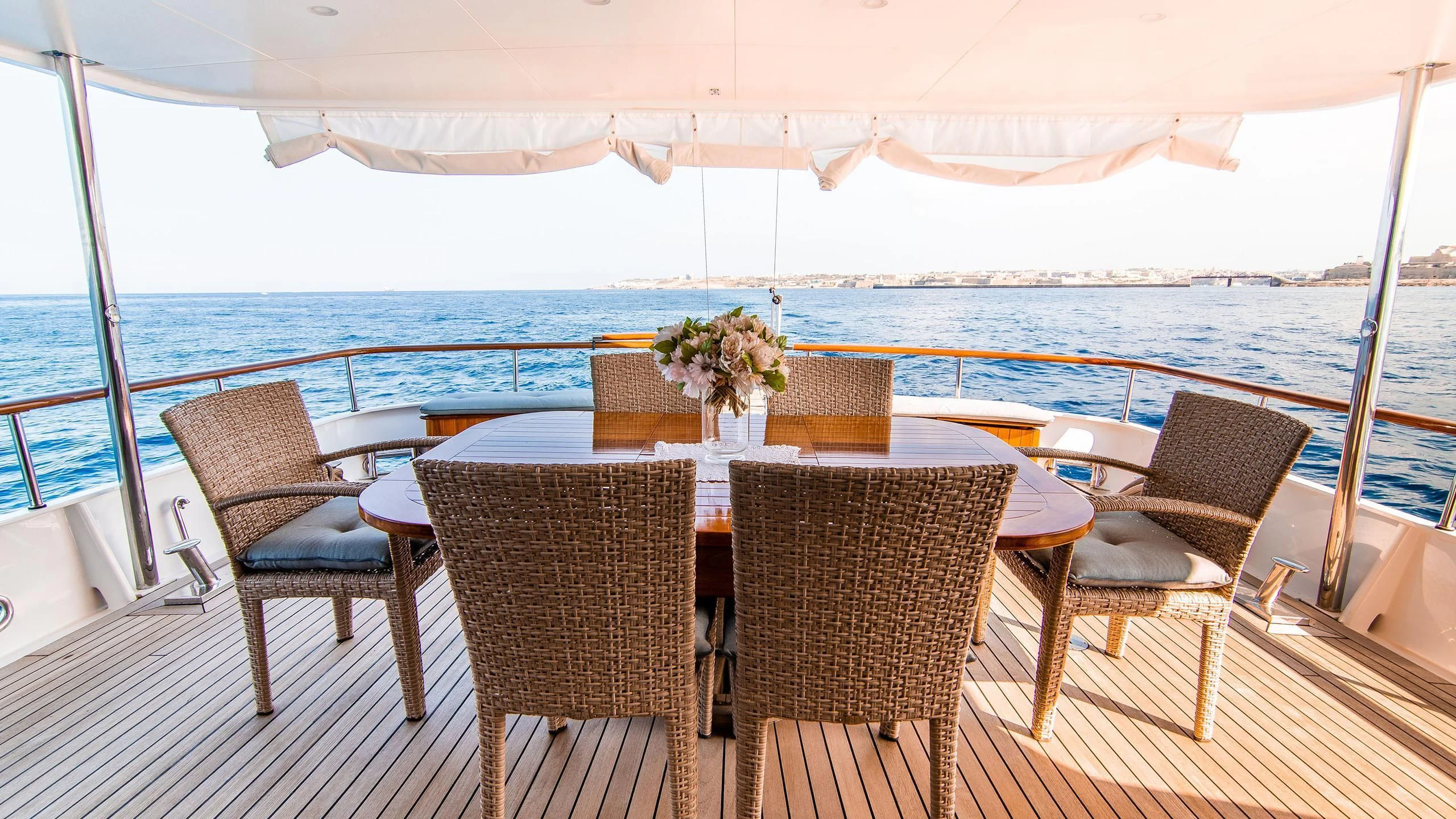 a table set for a meal on a deck overlooking the ocean aboard A&A Yacht for Charter