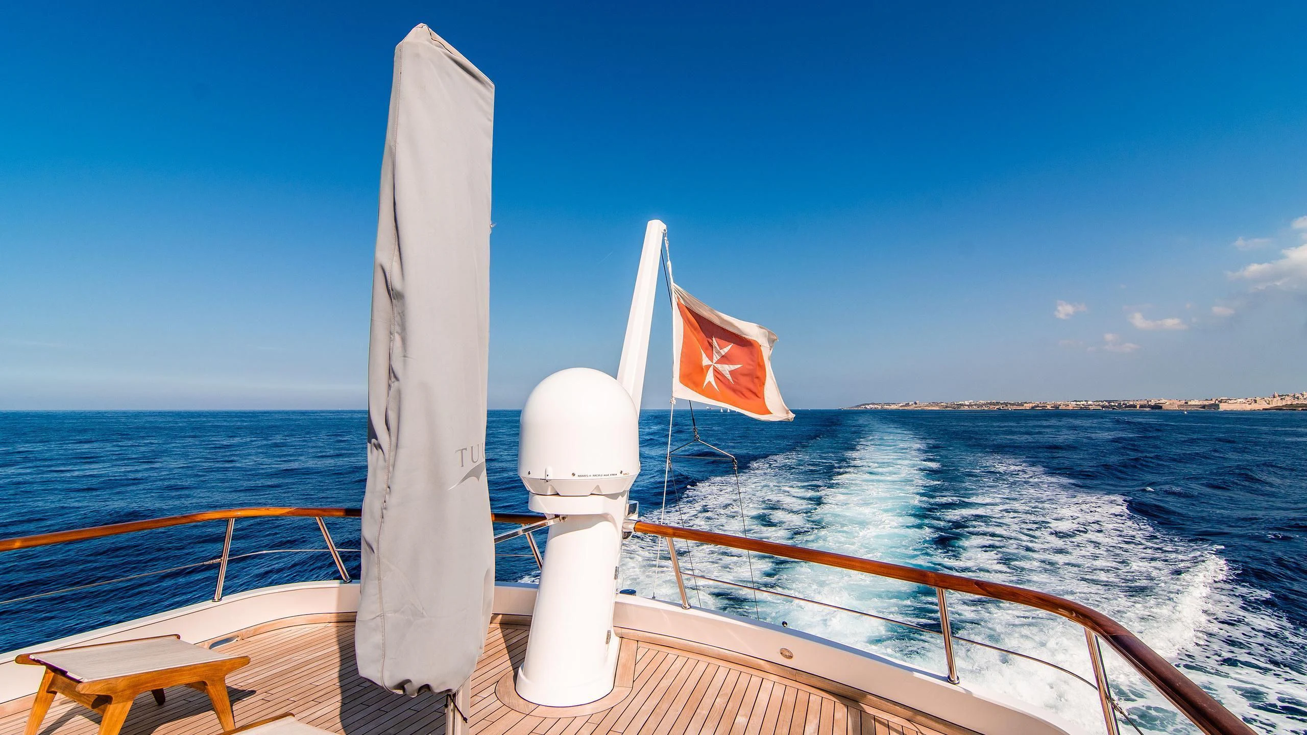 a boat with a flag on the front aboard A&A Yacht for Charter
