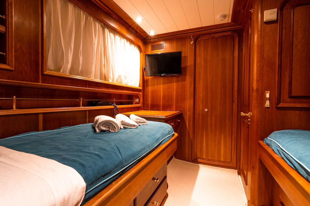 a bedroom with a bed and a television aboard A&A Yacht for Charter
