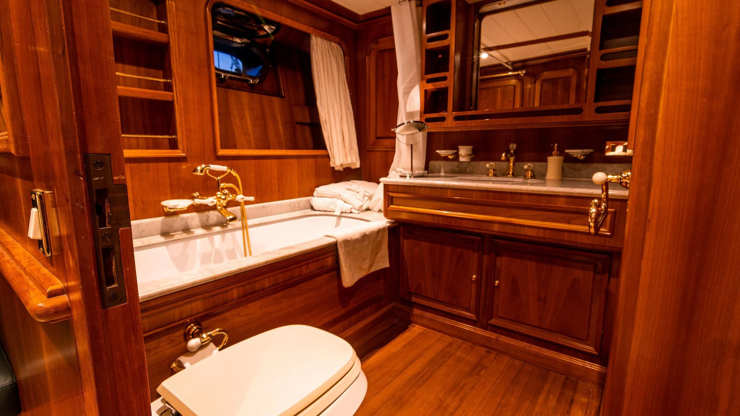 a bathroom with a tub sink and cabinets aboard A&A Yacht for Charter