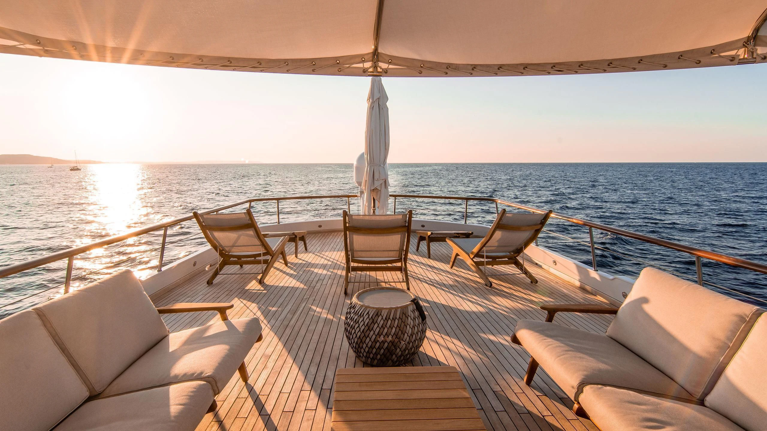 a deck with chairs on it and a body of water in the background aboard A&A Yacht for Charter