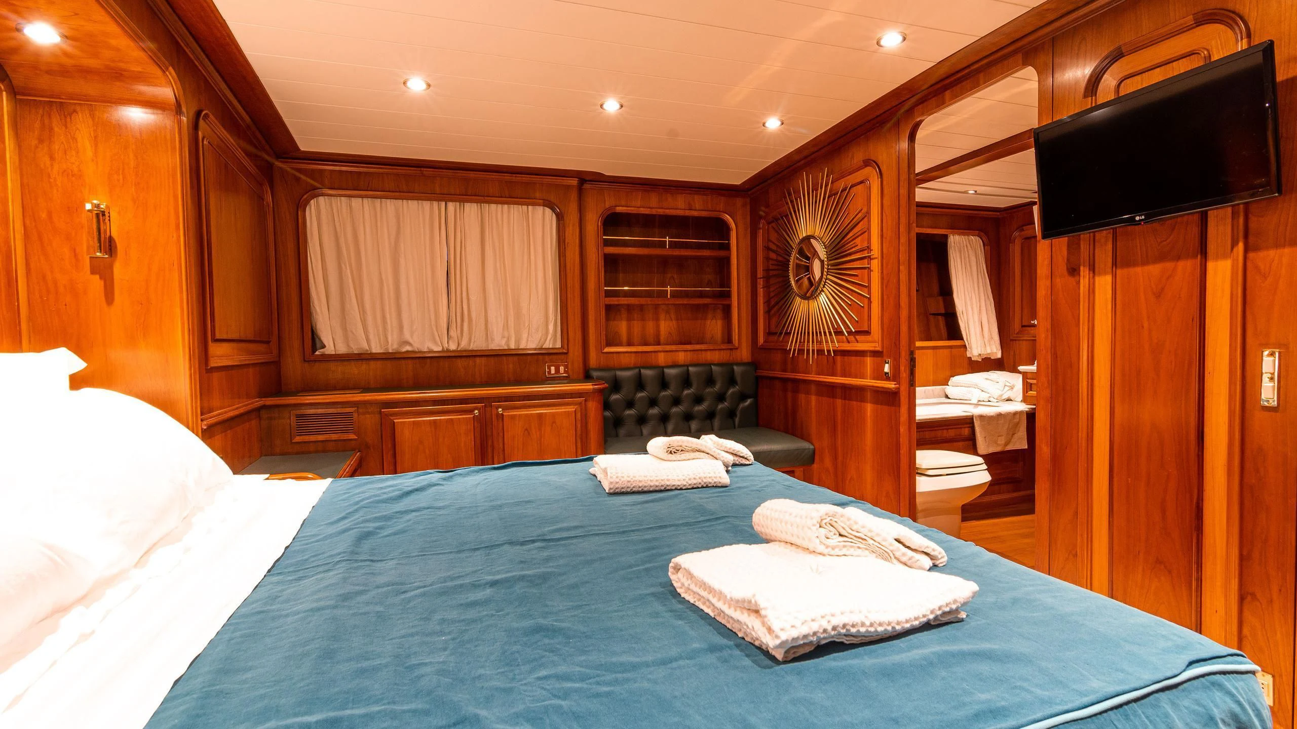 a room with a bed and a television aboard A&A Yacht for Charter