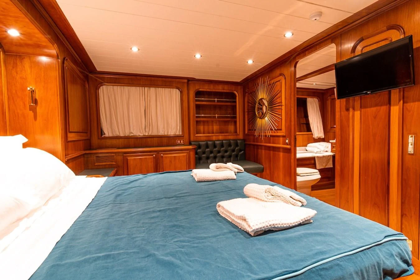 a room with a bed and a television aboard A&A Yacht for Charter