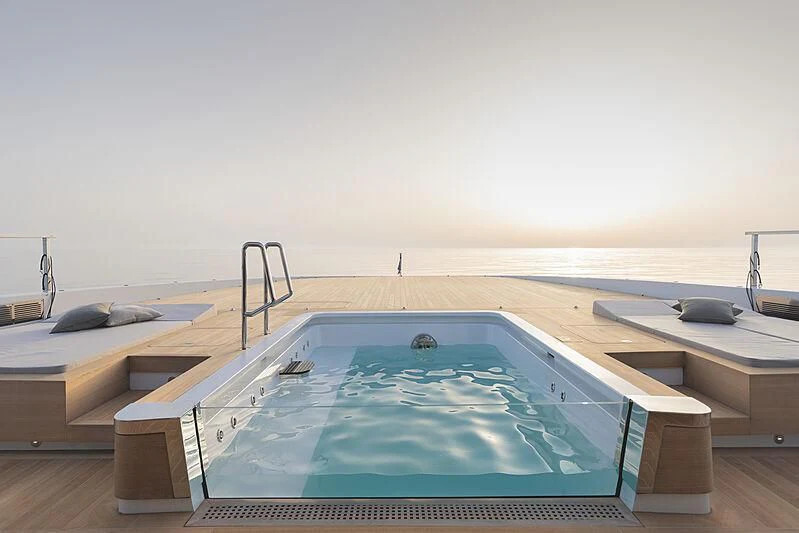 a pool table and chairs in a room with a large blue pool aboard LEMON TREE Yacht for Charter