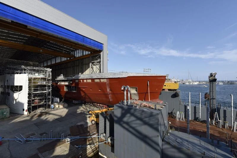 a large boat docked at a pier aboard LEMON TREE Yacht for Charter