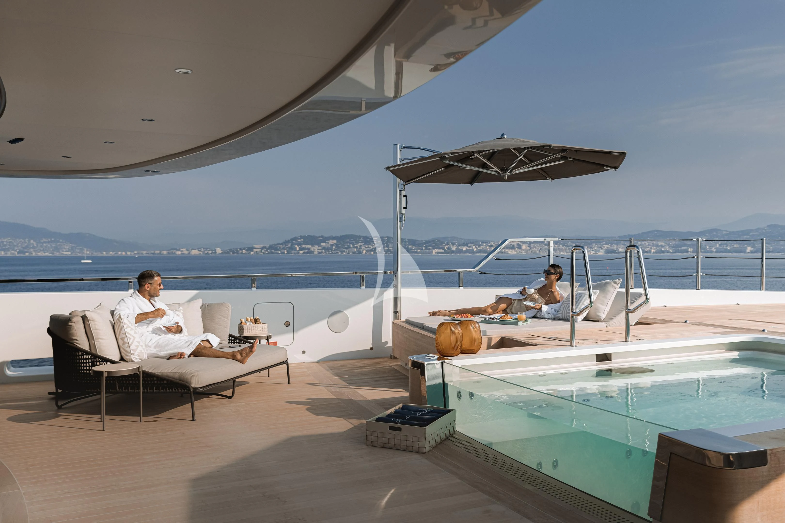 a couple of people sitting on chairs by a pool aboard LEMON TREE Yacht for Charter