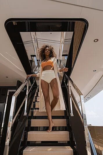 a woman in a dress on a flight of stairs aboard LEMON TREE Yacht for Charter