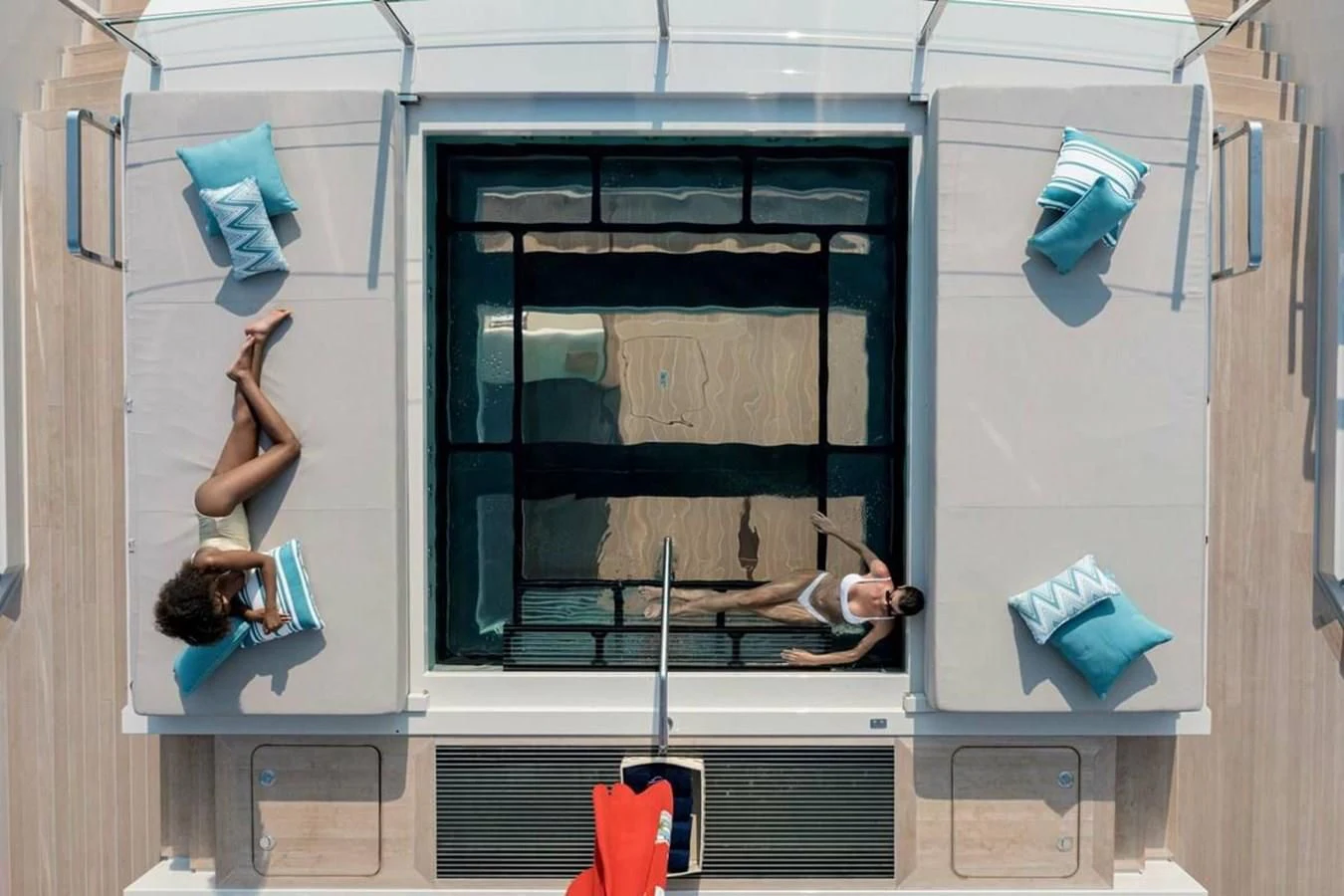 a person standing in front of a window with a blue flag and a red flag aboard LEMON TREE Yacht for Charter