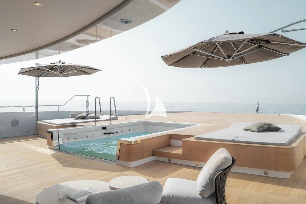 a room with a pool table and chairs and a large umbrella aboard LEMON TREE Yacht for Charter
