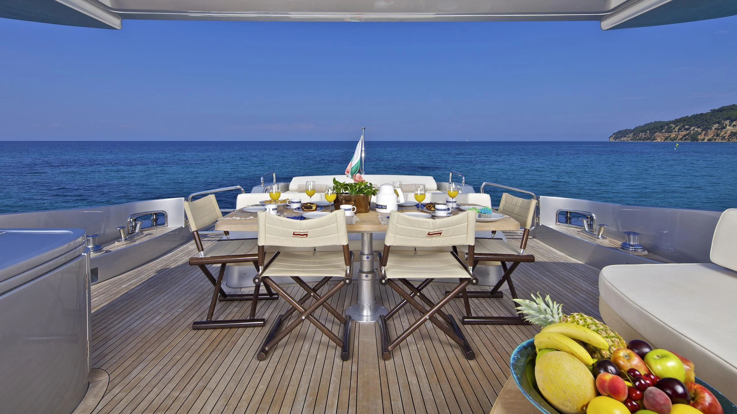 a table with chairs on it next to a body of water aboard THEA MALTA Yacht for Sale