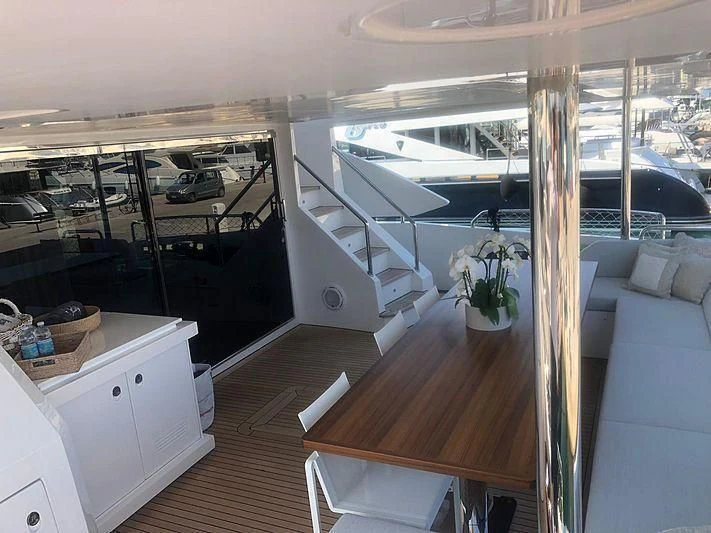 a room with a large window and a table with chairs and a boat aboard KALA Yacht for Sale