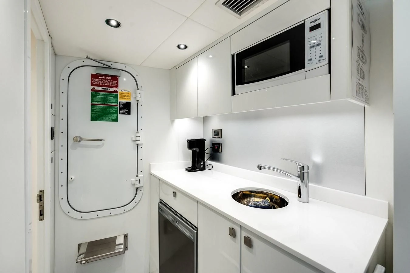 a white kitchen with a microwave oven aboard TRIGGER HAPPY Yacht for Sale