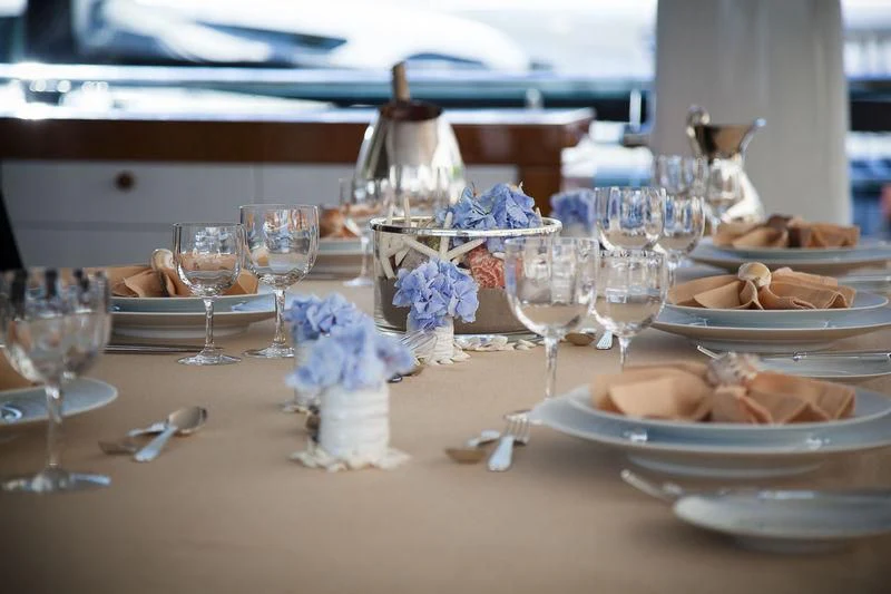 a table with plates and glasses aboard LADY BRAVE Yacht for Sale