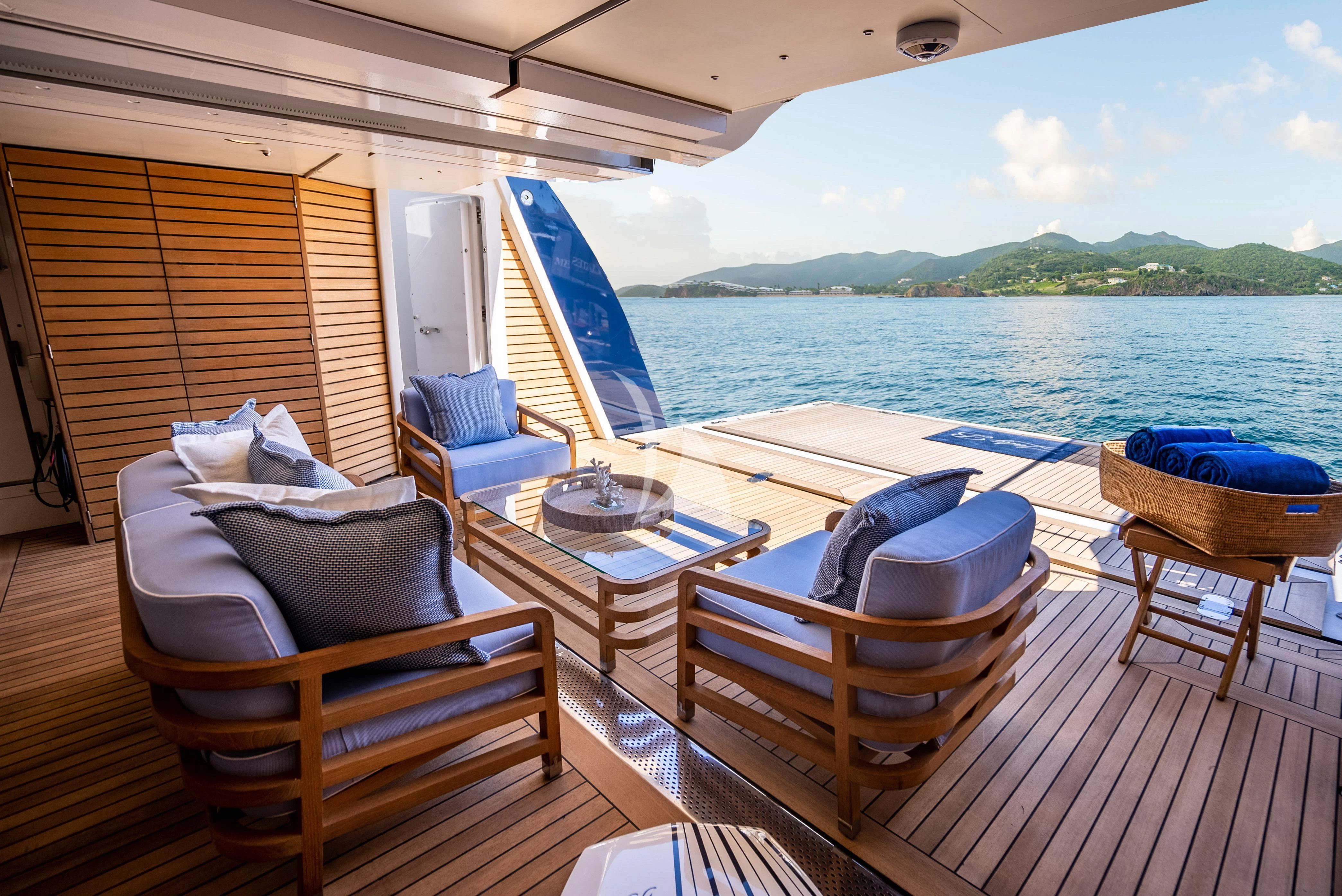 a deck with a table chairs and a view of the water aboard LADY BRAVE Yacht for Sale
