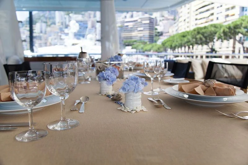 a table with plates and glasses aboard LADY BRAVE Yacht for Sale
