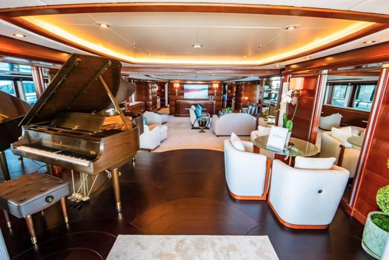 a room with a piano and chairs aboard LADY BRAVE Yacht for Sale