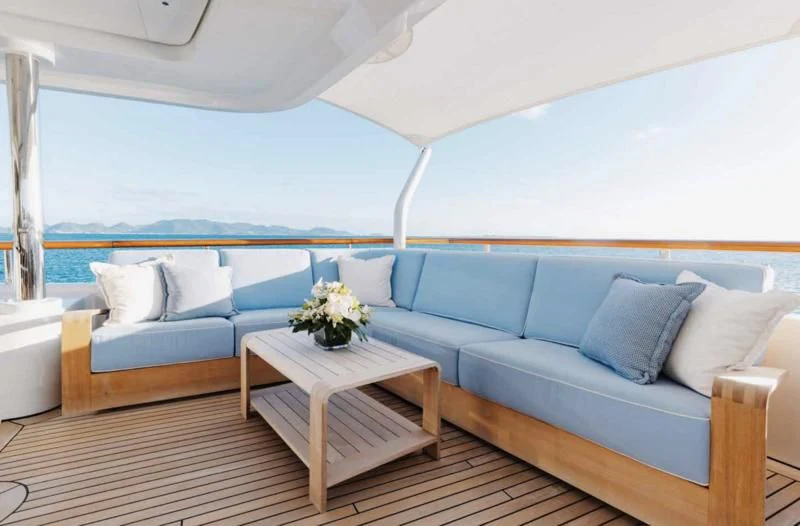 a blue couch with white pillows aboard LADY BRAVE Yacht for Sale