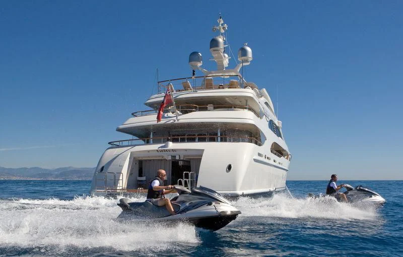a boat with a large ship in the background aboard LADY BRAVE Yacht for Sale