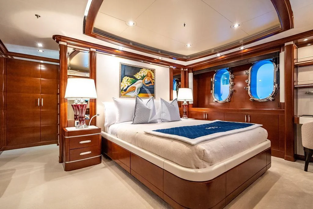 a bedroom with a bed and a desk aboard LADY BRAVE Yacht for Sale