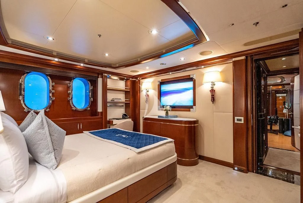 a room with a bed and a tv on the wall aboard LADY BRAVE Yacht for Sale