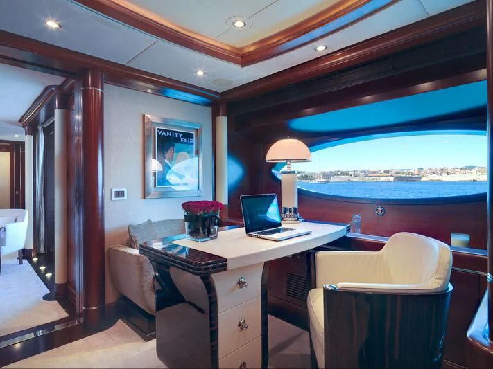 a room with a desk and a window with a view of the water aboard LADY BRAVE Yacht for Sale