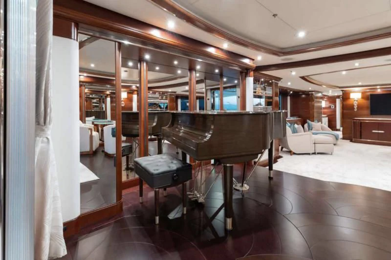 a large room with a piano aboard LADY BRAVE Yacht for Sale