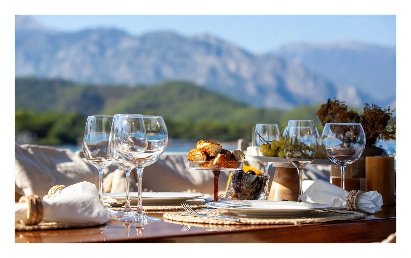 a table with food and wine glasses aboard BERING B82 Yacht for Sale