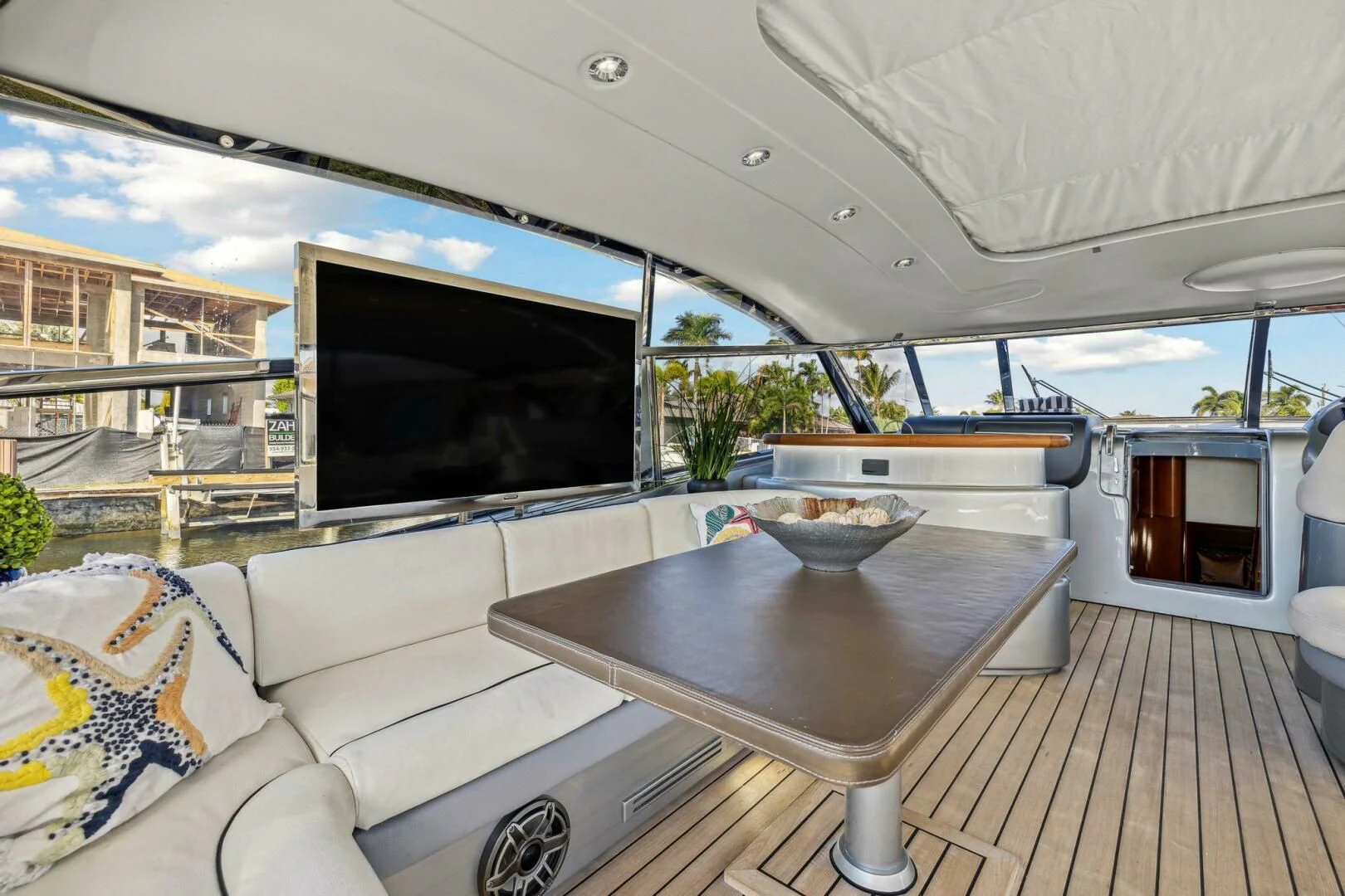 a living room with a large flat screen television and a table aboard ALCHEMY Yacht for Sale
