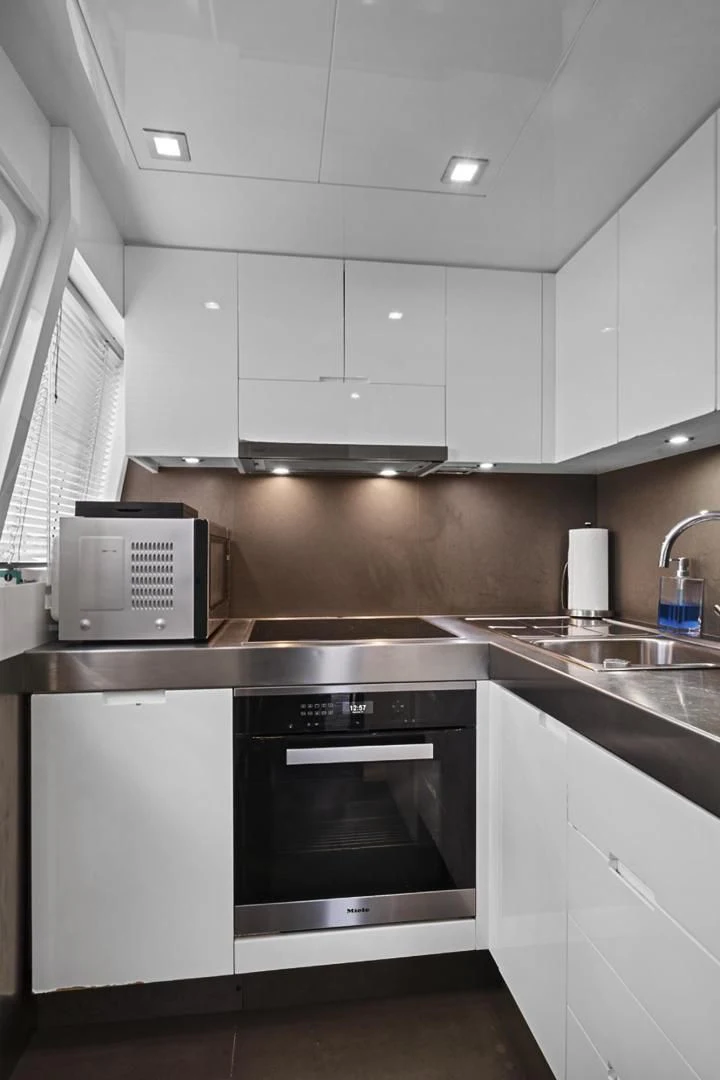 a kitchen with white cabinets aboard EL PATRON Yacht for Sale