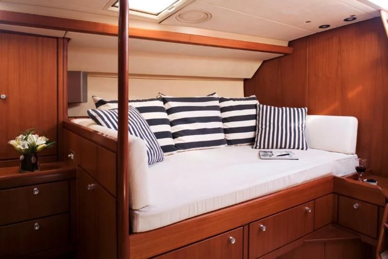 a bed with white and black striped pillows aboard ABEON Yacht for Charter