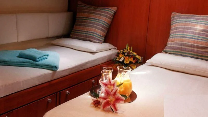 a bed with a tray of food and a candle on it aboard ABEON Yacht for Charter