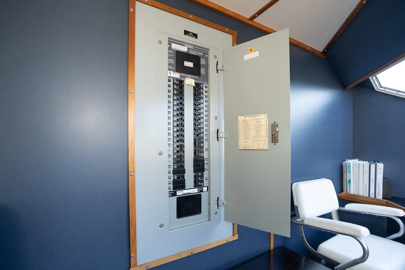 a room with a white door and a chair and a table aboard DRAGONFLY Yacht for Sale